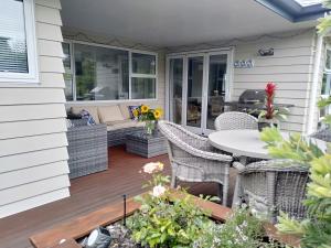 een patio met een tafel en stoelen op een huis bij Hidden Gem in Greytown