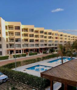 een groot appartementencomplex met twee zwembaden ervoor bij Portosaid بورتو سعيد (غرفه وصاله ) in `Ezbet Shalabi el-Rûdi