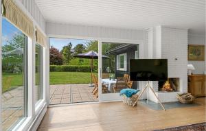 a screened in porch with a flat screen tv at 2 Bedroom Pet Friendly Home In Hornbk in Hornbæk