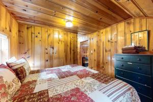 Joseph的住宿－Mount Bonneville，一间卧室设有一张床和木墙