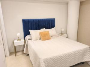 Exclusivo apartamento Torre Deco Armani Recoleta في بوينس آيرس: غرفة نوم بسرير كبير مع لوح رأس أزرق +30 صورة