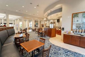 a restaurant with tables and chairs and a counter at Best Western PLUS Westgate Inn and Suites in Leland