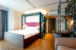 YOTEL Manchester Deansgate في مانشستر: غرفة نوم بسرير وكرسي