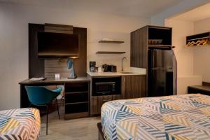 Pokój hotelowy z łóżkiem, biurkiem i kuchnią w obiekcie Studio 6 Grand Junction, CO w mieście Grand Junction
