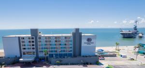 科珀斯克里斯蒂DoubleTree by Hilton Corpus Christi Beachfront的海滩上的一家酒店，海面上有一艘游轮