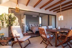 モガンにあるDoñana 1213 &1214, lux penthouseのテーブルと椅子のあるダイニングルームと寝室