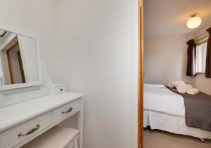 Dormitorio pequeño con cama y espejo en Swinton 