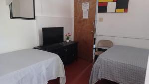 1 dormitorio con 1 cama, TV y mesa en Drifters@One Mile en Negril