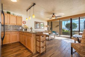 a large kitchen with wooden cabinets and a table at 106 Milowai in Wailuku