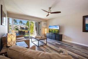 sala de estar con sofá y TV de pantalla plana en 126 Hale Kamaole, en Wailea