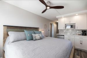 Schlafzimmer mit einem Bett und einem Deckenventilator in der Unterkunft 401 Nani Kai HaleBeachfrontNewly Remodeled in Kihei