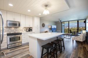 a kitchen with a large island with bar stools at 4-309 Kamaole Sands**Newly Remodeled** Steps to Kamaole 3 Beach! in Wailea