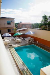 una piscina con mesas y sombrillas en un edificio en Hotel Itatiaia, en São Luís