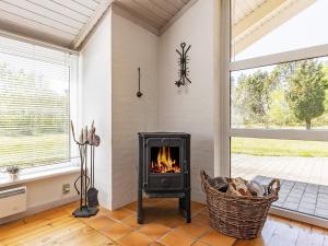 a fireplace in a living room with a window at 5 person holiday home in L s in Læsø