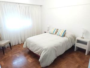 Un dormitorio blanco con una cama y una ventana. en Departamento Plaza, en Bahía Blanca