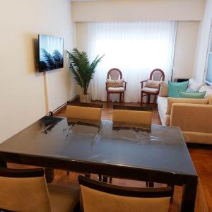 Una sala de estar con una mesa y sillas y un sofá. en Departamento Plaza, en Bahía Blanca
