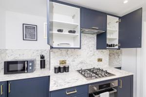 een keuken met blauwe kasten en een fornuis met oven bij Sea View I Garden I SeafrontI One Bedroom Flat I King Size Bed I 2 Mins Walk to Seafront in Brighton & Hove