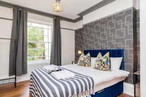 een slaapkamer met een bed met een blauw hoofdeinde bij Sea View I Garden I SeafrontI One Bedroom Flat I King Size Bed I 2 Mins Walk to Seafront in Brighton & Hove