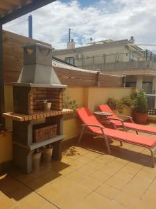 a patio with two chairs and a fire place at Casa Maite in Palamós