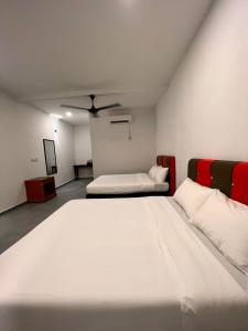 a bedroom with two beds and a ceiling fan at Dumba Bay Tioman in Tioman Island