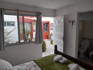 a bedroom with a bed and a window and a bathroom at Posada Mela in Colonia del Sacramento