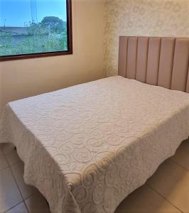 a bed sitting in a room with a window at Flat Paraíso em Serra Negra- Bezerros/PE in Bezerros