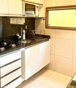 uma cozinha com um lavatório e um fogão em Flat Paraíso em Serra Negra- Bezerros/PE em Bezerros