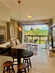 uma cozinha e sala de estar com mesa e cadeiras em Flat Paraíso em Serra Negra- Bezerros/PE em Bezerros