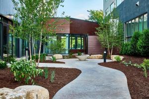 a walkway in front of a building with trees at Courtyard by Marriott Minneapolis West in Saint Louis Park