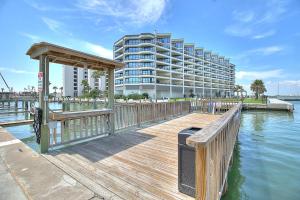 a wooden dock with a building in the background at Bay Tree D2 in Port Aransas