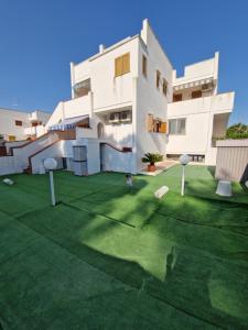 a large white building with a green lawn in front of it at Casamarina Orchidea in Campomarino