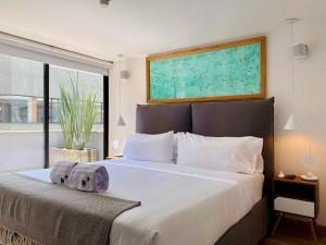 1 dormitorio con 1 cama blanca grande y ventana grande en Amazing 1BR with Terrace in Chico, en Bogotá