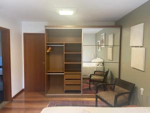 a room with a closet and a bedroom with a bed at Suite residencial, Villa da Luz in Curitiba