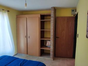 1 dormitorio con estante de libros y armario en El Aromito en Alta Gracia