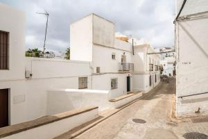 Una calle vacía con edificios blancos en una ciudad. en Preciosa casa independiente con increibles vistas, en Vejer de la Frontera