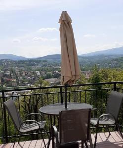 um guarda-chuva sentado em cima de uma mesa na varanda em Mieszkanko z tarasem em Limanowa