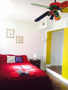 a bedroom with a red bed and a ceiling fan at Miami House in Miami