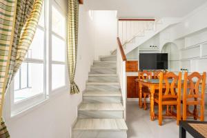 una escalera que conduce a un comedor y una cocina con mesa en Preciosa casa independiente con increibles vistas, en Vejer de la Frontera