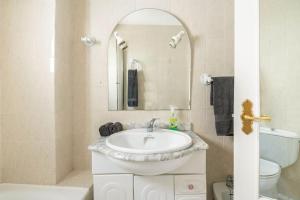 Un baño con lavabo, inodoro y espejo. en Preciosa casa independiente con increibles vistas, en Vejer de la Frontera 80 fotos más