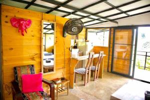 Habitación con paredes de madera, mesa y sillas. en Cabaña entre las montañas Tierra Mia - Eje Cafetero, en Manizales