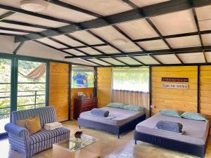 Habitación con 2 camas, sofá y mesa. en Cabaña entre las montañas Tierra Mia - Eje Cafetero, en Manizales