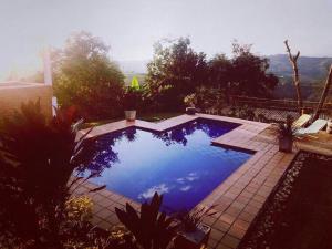 a swimming pool with blue water in a yard at Cabaña entre las montañas Tierra Mia - Eje Cafetero in Manizales