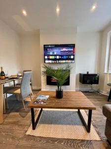 a living room with a table and a tv at Paul Properties in Ruislip