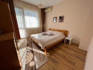 a small bedroom with a bed and a window at Apartment Acacia in Varna City