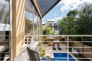 a balcony with chairs and a swimming pool at Tulum Private Modern Villa-Pool Beds-AC-Internet-Parking-Grill in Tulum