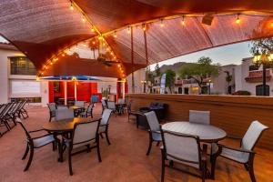 un patio restaurante con mesas, sillas y luces en Scottsdale Camelback Resort en Scottsdale