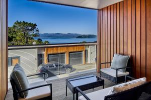 a balcony with a view of a car parked on a deck at Brand New Townhouse with Ocean Views in Wellington