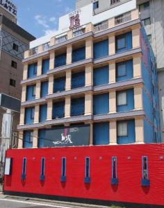 un grande edificio con una parete rossa di fronte di HOTEL Iz bayside 大人専用 a Funabashi