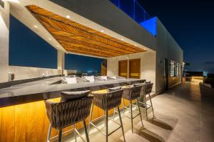 a bar on the roof of a building with chairs at Kippal - Modern Oasis - ApartHotel in Cozumel