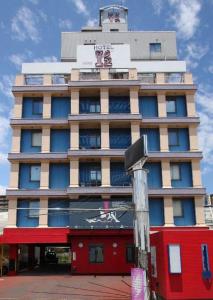 Un palazzo alto con un cartello davanti di HOTEL Iz bayside 大人専用 a Funabashi